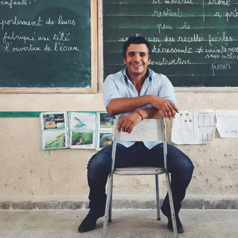 Lotfi Hamadi president of wallah we can sitting on a chair in a classroom